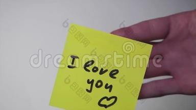 画画`我爱你`在黄纸上。 在白色背景上我爱你